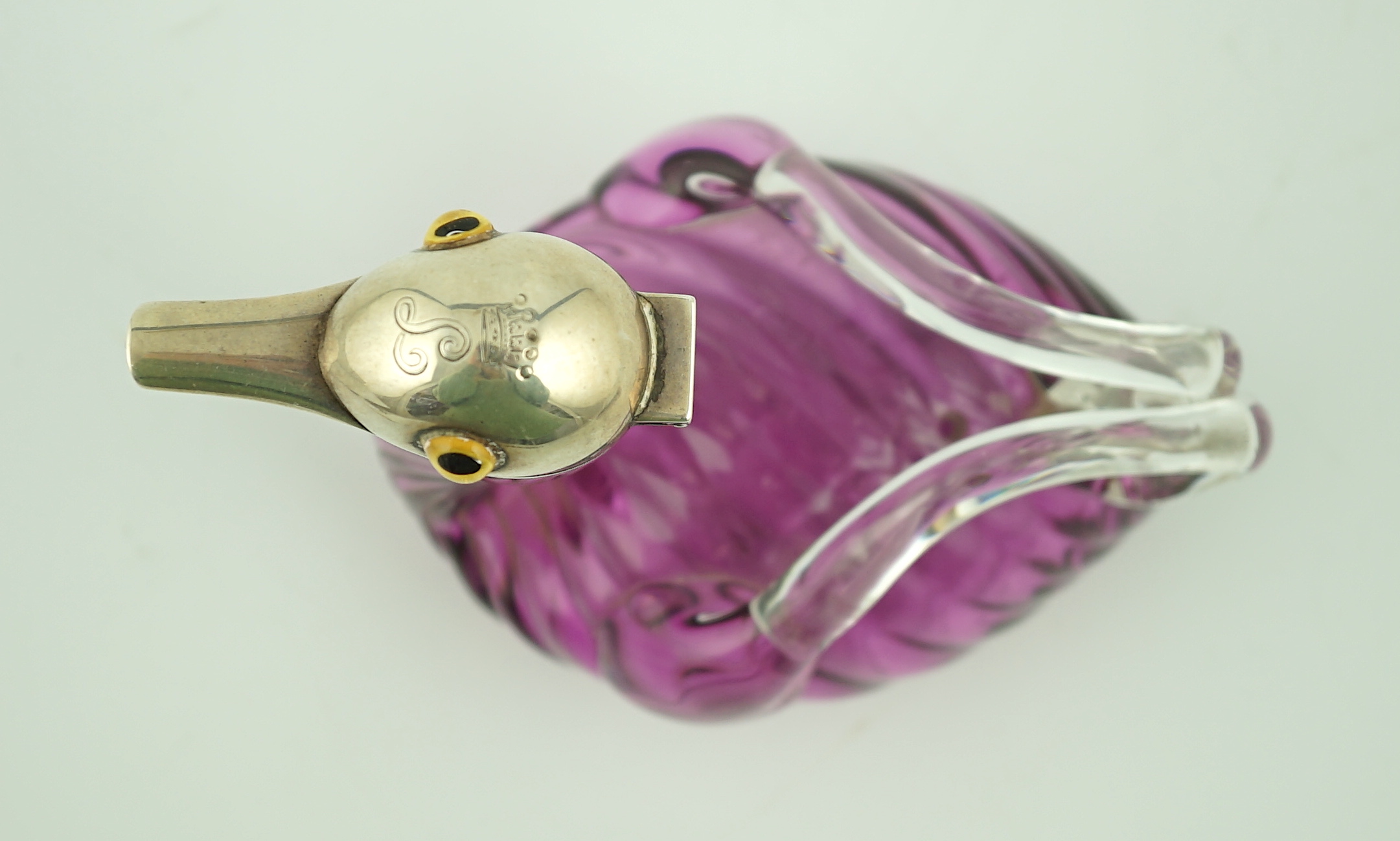 A late Victorian novelty silver mounted amethyst coloured glass liqueur jug, modelled as a duck, by Saunders & Shepherd, retailed by Thornhill